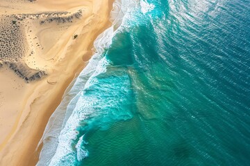 A breathtaking aerial view of a turquoise ocean meeting golden sands