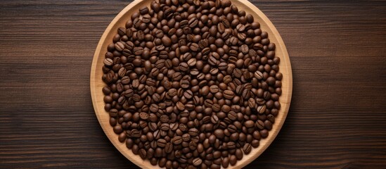 Fototapeta premium A top down view of a group of coffee beans arranged on a bamboo plate placed on a wooden table with ample empty space around them for copy or additional images