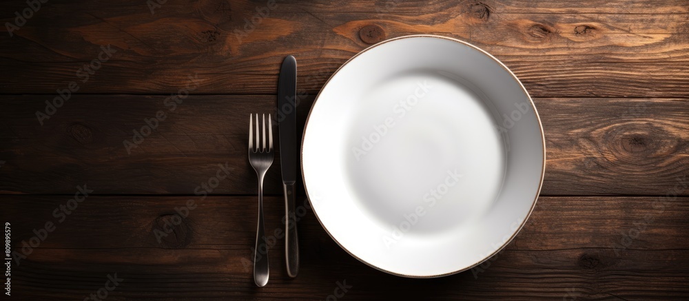 Leinwandbilder an overhead view of an empty vintage white plate placed on a black wooden table is captured in this 