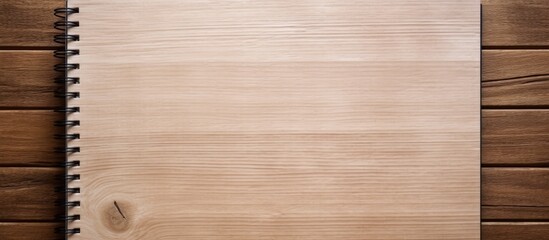 A wooden background with a blank notebook and a pencil offering ample space for writing or drawing
