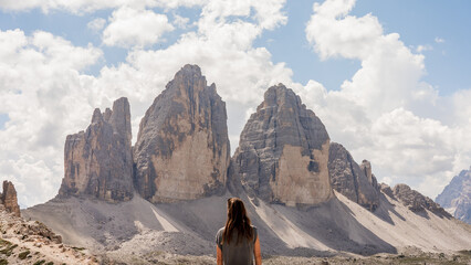 Woman in front of towering mountains. A sense of freedom. Tre Cime di Lavaredo. Dolomites. Italy