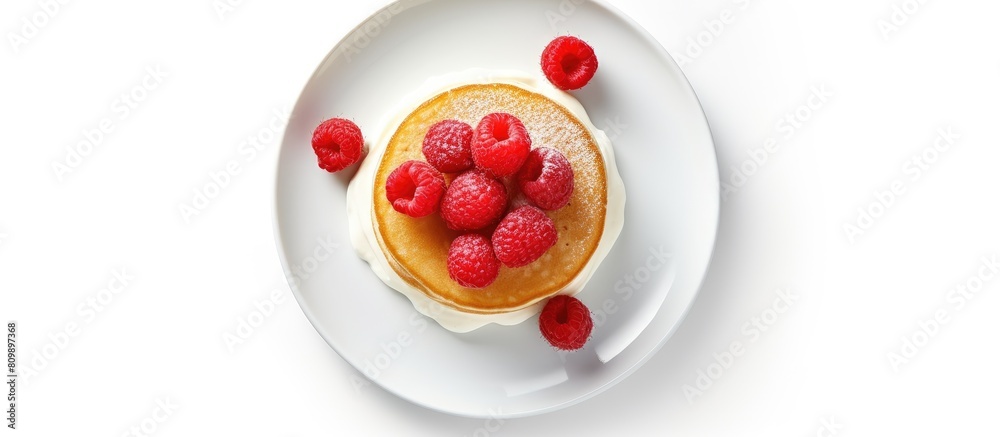 Poster Top view of fluffy pancakes topped with fresh raspberries presented on a white ceramic plate with ample copy space image