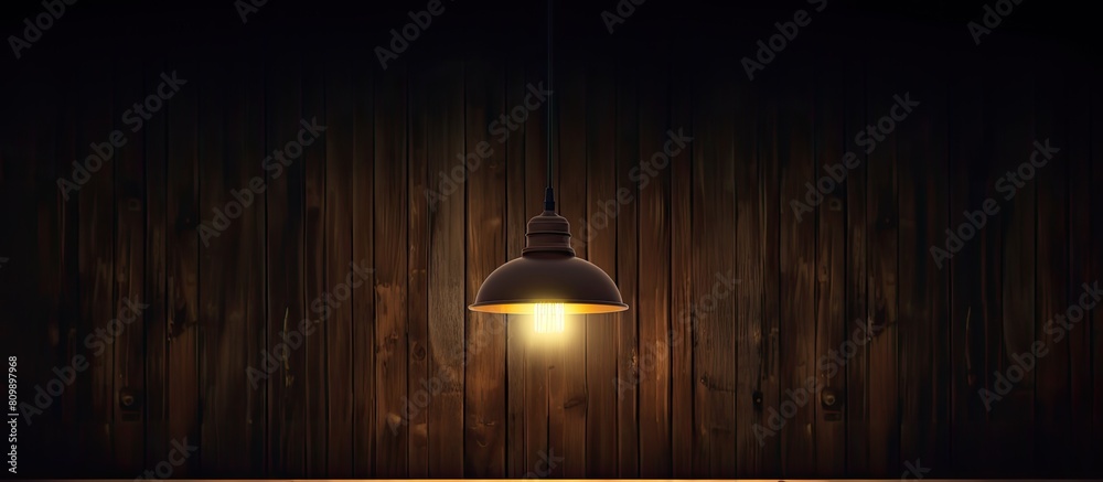 Poster a hanging lamp on the ceiling casts a gentle glow illuminating the dark wooden room creating a capti