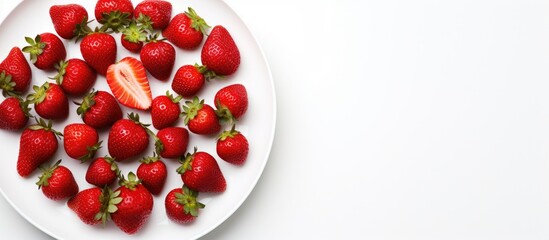 A close up view from above of a plate containing fresh and healthy strawberries The plate is isolated on a white background offering copy space for text