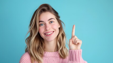 Young cute woman raises index finger, smiles, relaxes, looks at camera , please remember  concept