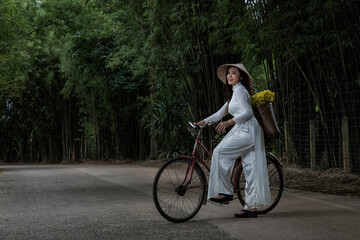 person riding a bicycle.  woman with in Vietnam traditional with  bicycle.
