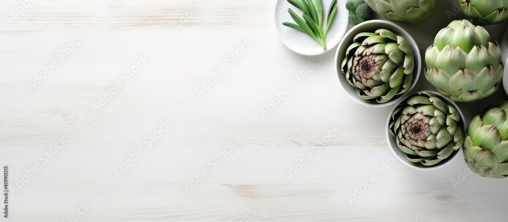 Poster The white wooden table is adorned with a bowl filled with powder and fresh artichokes creating an appealing flat lay composition Ample space is available for text