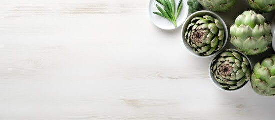 The white wooden table is adorned with a bowl filled with powder and fresh artichokes creating an appealing flat lay composition Ample space is available for text - Powered by Adobe