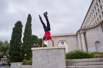 young sporty man doing the pino in the city with inline skates on