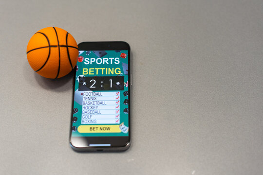 smartphone with application for sport bets and a basketball ball, concept of online bets  - Powered by Adobe