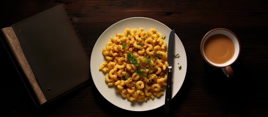 A top down view of a white bowl filled with Homemade Chili Mac and Cheese sprinkled with parsley The dish is placed on a black surface with a blank notepad nearby The image offers ample copy space