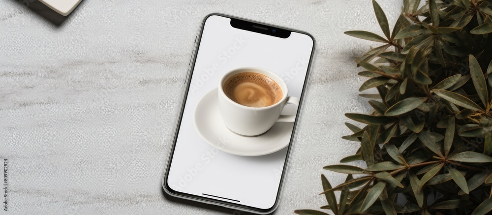 Leinwandbilder a white table holds a phone mockup accompanied by a cup of coffee and leaves for a more visually app