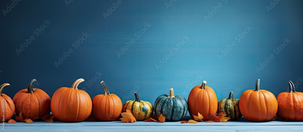 Poster close up of carved pumpkins on a table over a blue background representing the holidays halloween an