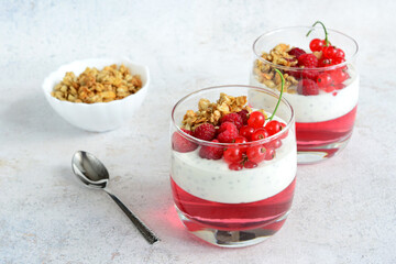 a glass of yogurt with berries and raspberry jelly and walnut