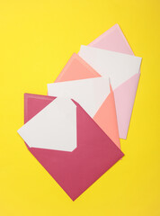 Pink envelopes with white blank letters on a yellow background. Creative layout