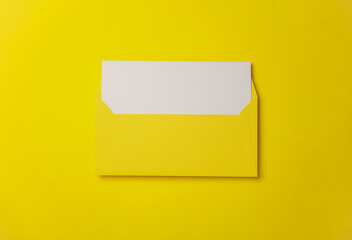 Yellow envelope with white blank letter on a yelllow background. Creative layout