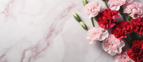 Top view of a stunning bouquet of pink and red carnations on a marble table This beautiful arrangement is perfect for Mother s Day or Valentine s Day with a flat lay design and plenty of copy space f