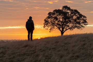 Fototapeta premium Person Standing on Hill With Tree in Background