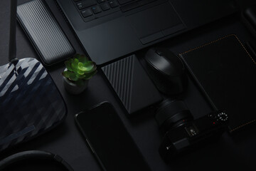 Modern black gadgets and accessories. Laptop, camera, smartphone, notepad, external hard drive, USB...