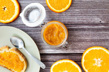 Tasty and healthy homemade orange marmalade. Close-up view of healthy breakfast with homemade orange marmalade in a glass jar.