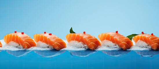 A panoramic photo captures a vibrant copy space image of delicious freshly prepared nigiri sushi featuring succulent pieces of salmon resting on a striking blue and orange surface