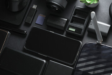 Modern photographer's equipment on a black background. Gadgets and accessories in black. Flat lay....