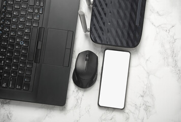 Flat lay composition with laptop, smartphone, Wi-Fi router on a marble background. Mockup for design
