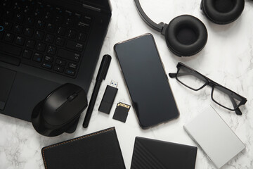 Flat lay composition with laptop, smartphone, notebook, external hard drive, SD memory card, flash...