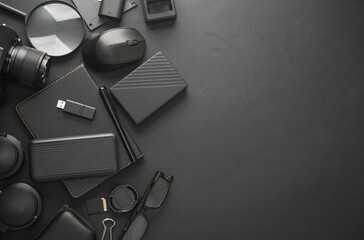 Flat lay composition of Modern black gadgets and accessories on a dark black background. Top view....