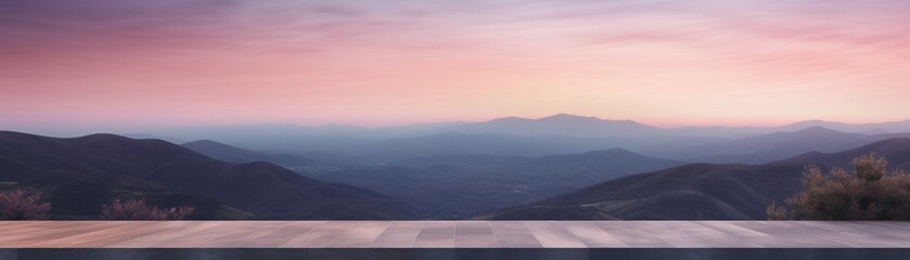 A wooden deck with a view of a mountain landscape at sunset.