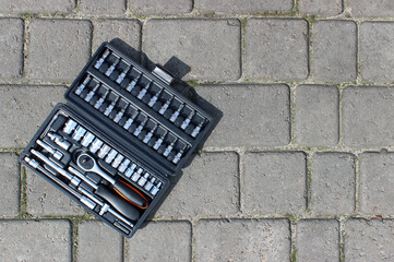 A set of repairing tools in a plastic case on a concrete paving slabs 
 - obrazy, fototapety, plakaty