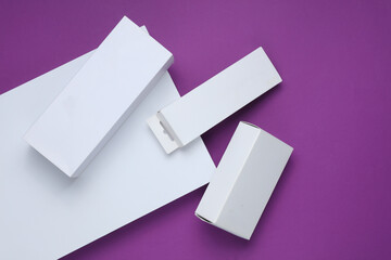 Different shapes of white cardboard boxes for presentation products on a purple background. Mockup...