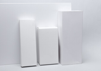 Different shapes of white cardboard boxes for presentation products on white background. Mockup for design.