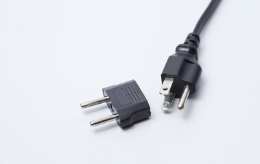 US socket with adapter to EU socket on white background