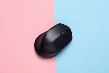 Black wireless PC mouse on a blue-pink background
