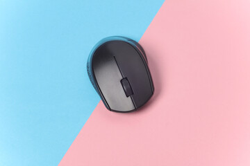 Black wireless PC mouse on a blue-pink background