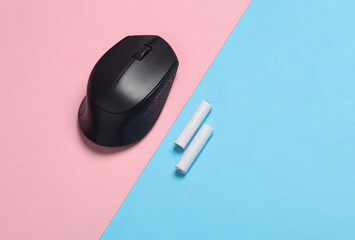 Wireless PC mouse with USB flash drive and batteries on pink blue background