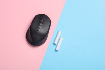 Wireless PC mouse with USB flash drive and batteries on pink blue background