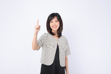 A Young asian woman pointing finger to free copy space isolated on white studio background