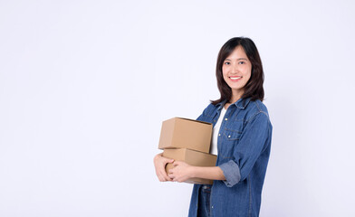 young asian woman wearing white t-shirt and denim shirt holding parcel box isolated on white studio background, Delivery courier and shipping service concept.