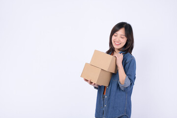 young asian woman wearing orange t-shirt and denim shirt holding parcel box isolated on white studio background, Delivery courier and shipping service concept.