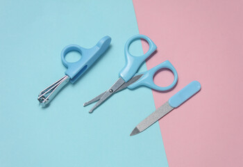Baby care set on a blue-pink background. Scissors, nail file, tweezers. Flat lay