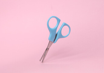 Floating Scissors for baby care on pink background. Top view