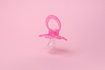 Floating Baby pacifier on a pink background