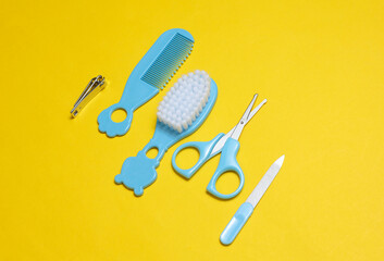 Baby care set on yellow background. Scissors, comb, nail file and tweezers.
