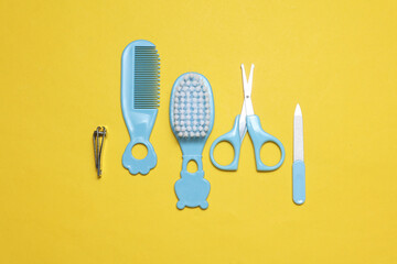 Baby care set on yellow background. Scissors, comb, nail file and tweezers.