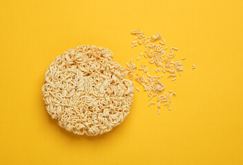 Dry instant noodles on yellow background