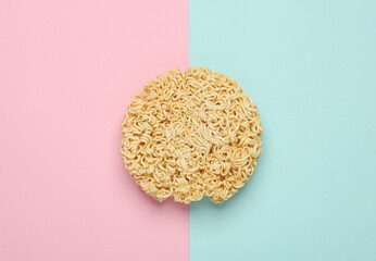 Dry instant noodles on pink blue background