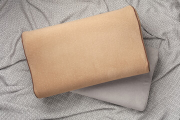 Two orthopedic pillows on a gray blanket