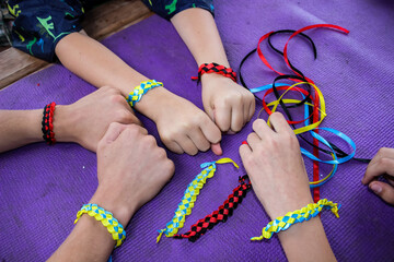 master class with children on making bracelets, weaving of different-colored stitches, hand-made...